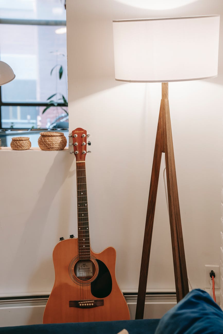 acoustic guitar at wall with window at home